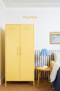 a yellow locker next to a bed in a room with blue and white striped walls