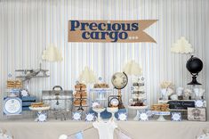 a dessert table set up for a baby's first birthday party with blue and white decor