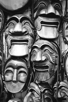 many masks are lined up together on the wall in this black and white photo,