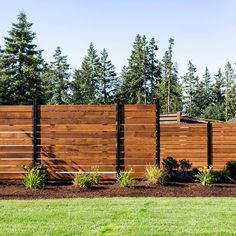 a wooden fence in front of some trees