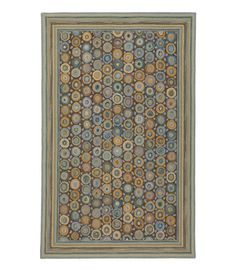 an area rug with various circles and colors on the ground, including blue, green, brown