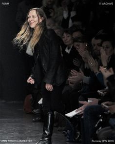 a woman is walking down the runway at a fashion show