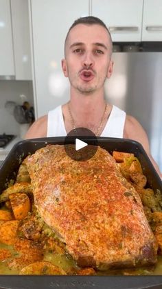 a man holding up a pan with food in it and making a face for the camera