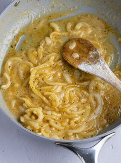 a wooden spoon in a bowl of noodles