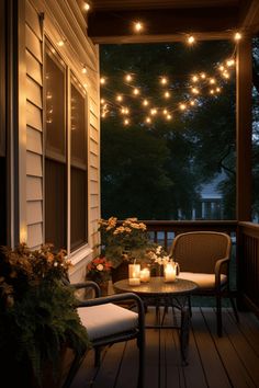 an outdoor patio with lights strung over it and two chairs sitting on the front porch