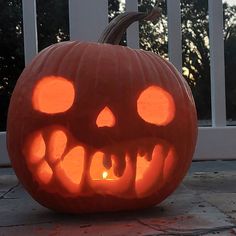 a carved pumpkin with glowing eyes and teeth