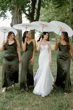 four bridesmaids in green dresses holding umbrellas