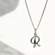 A necklace made of 925 silver with a curved letter pendant is a timeless and classic piece of jewelry that fits with many different outfits and occasions. The personal element of the initial pendant makes it a unique and meaningful gift. Letter R charm Total height with pendant bail: approx. 2 cm  Width x height without pendant bail: 0.9 cm x 1.5 cm  Chain length (selectable): - 40 cm  - 45 cm  - 50 cm  Material: 925 Sterling Silver This listing is only for letter "R". Please look for other lett R Necklace, Initial R, Gift Letter, Pendant Bail, Dainty Initial Necklace, Necklace Initial, Pendant Bails, Open Letter, Letter R