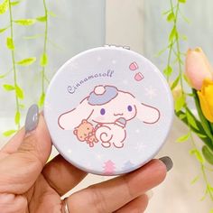 a person holding a compact case with a cartoon character on it