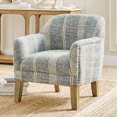 a blue chair sitting on top of a rug next to a table with a book