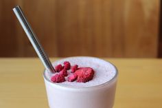 a drink with raspberries in it and a straw sticking out of the top