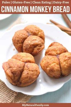 three cinnamon monkey bread muffins on a plate with cinnamon sticks in the background