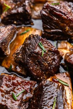 closeup of cooked meat with herbs on top and brown sauce in the middle, ready to be eaten