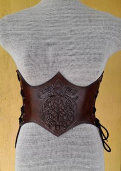 It is Handmade leather corset with Tooled beautiful designs. Handmade and hand dyed belt with high quality leather. It is adjustable with lace.  MEASUREMENTS: S/M : 66 cm - 74 cm / 26" in - 29"in M / L: 75 cm-85 cm / 29.5 "in - 33.5" in L / XL: 85 cm-95  cm / 33.5 "in - 37.4" in DETAILS: ► 100% handmade ► 100% genuine leather ► Made on your measurements ► Unique design ► Battle ready ► LARP standard ► Worldwide delivery NOTE: This item can be personalized on request (contact us) We remind our cu Steampunk Leather Corset Belt For Cosplay, Medieval Style Corset Belt For Festivals, Medieval Corset Belt For Festivals, Medieval Leather Fitted Corset, Steampunk Leather Corset For Cosplay, Fitted Leather Medieval Corset, Gothic Leather Corset Belt For Larp, Medieval Style Fitted Leather Corset, Gothic Leather Corset For Cosplay