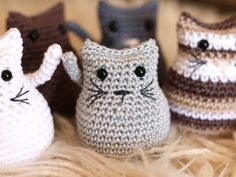 small crocheted cats sitting next to each other on top of a fur rug