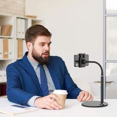 a man sitting at a desk with a coffee cup in front of him