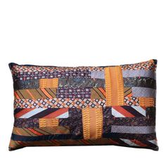 an orange and black patchwork pillow on a white background