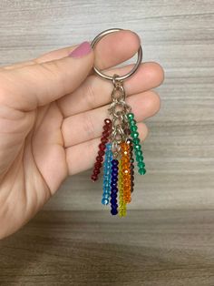 a hand holding a rainbow colored key chain