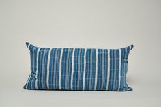 a blue and white striped pillow sitting on top of a table