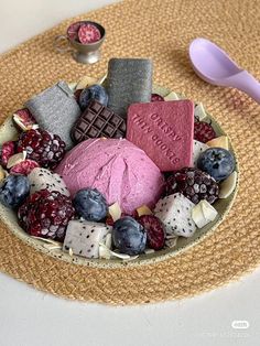 a bowl filled with different types of desserts on top of a table next to a spoon