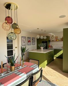 an open kitchen and dining room with green cabinets