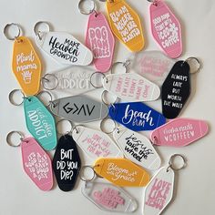 a bunch of key chains that have different colors and designs on them, all with words