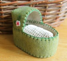 a close up of a stuffed animal in a small basket on a wooden table next to a wicker basket