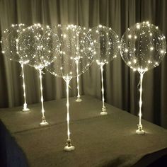 four lighted wine glasses sitting on top of a table