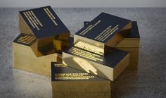 gold and black business cards stacked on top of each other