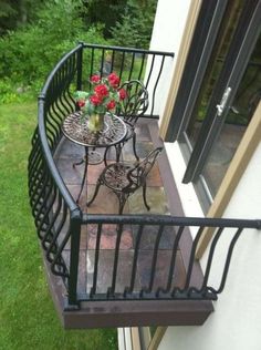 two small tables and chairs on a balcony with flowers in the potted planter