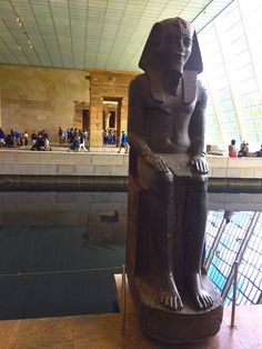 an egyptian statue sitting in the middle of a swimming pool