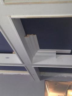 an unfinished ceiling with blue walls and white trim on the top part of the beams