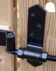 a close up of a black door hinge on a wooden fence with screws