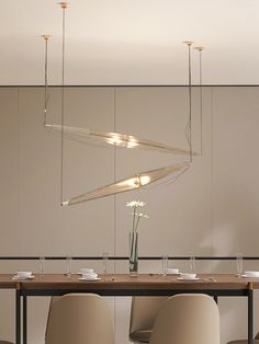 a dining room table with chairs and a chandelier hanging from the ceiling