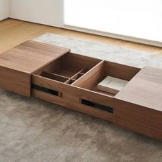 an open drawer on the floor in front of a window with a carpeted area