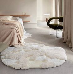 a bed room with a neatly made bed and a rug on the floor next to it