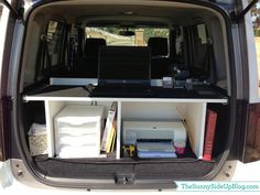 the back end of a van with an open laptop computer and other items in it