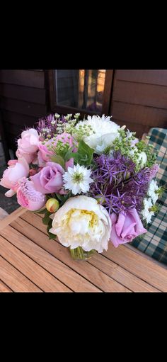 a bouquet of flowers sitting on top of a wooden table