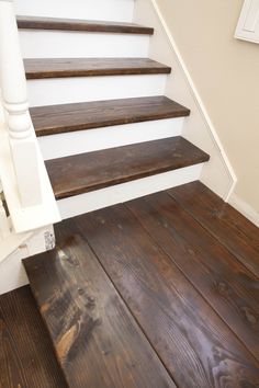 the stairs are made of wood and have white handrails