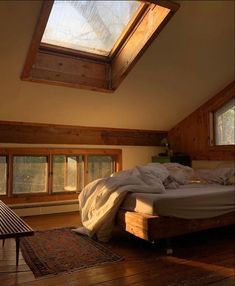 a bed sitting under a skylight in a bedroom