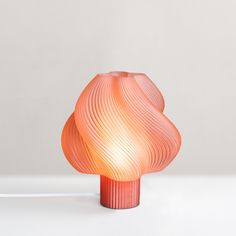 an orange lamp sitting on top of a white table