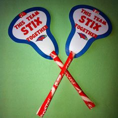 two red and blue spoons with stickers on them that say, this team stix together