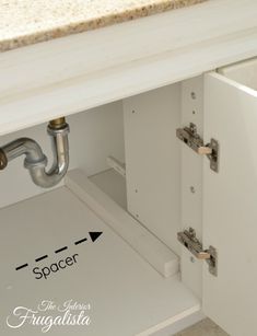 an open cabinet door showing the space under it and where to place the faucet