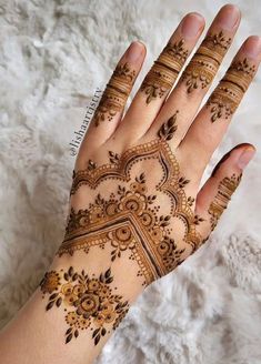 a woman's hand with henna tattoos on it