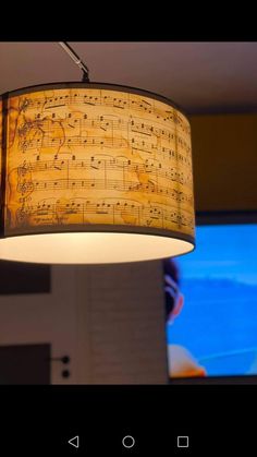 a lamp hanging from the ceiling with musical notes on it's fabric coverings