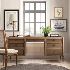 a wooden desk sitting in front of a window with a lamp on top of it