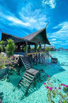 a house on stilts in the water with stairs leading up to it