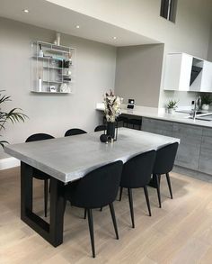 a dining room table with black chairs around it