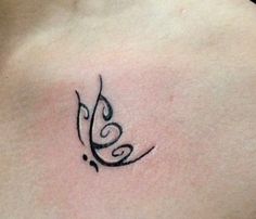 a tattoo on the back of a woman's chest that has an arabic script