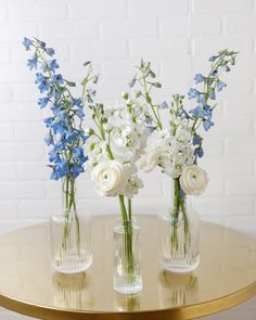 three vases with flowers are sitting on a table